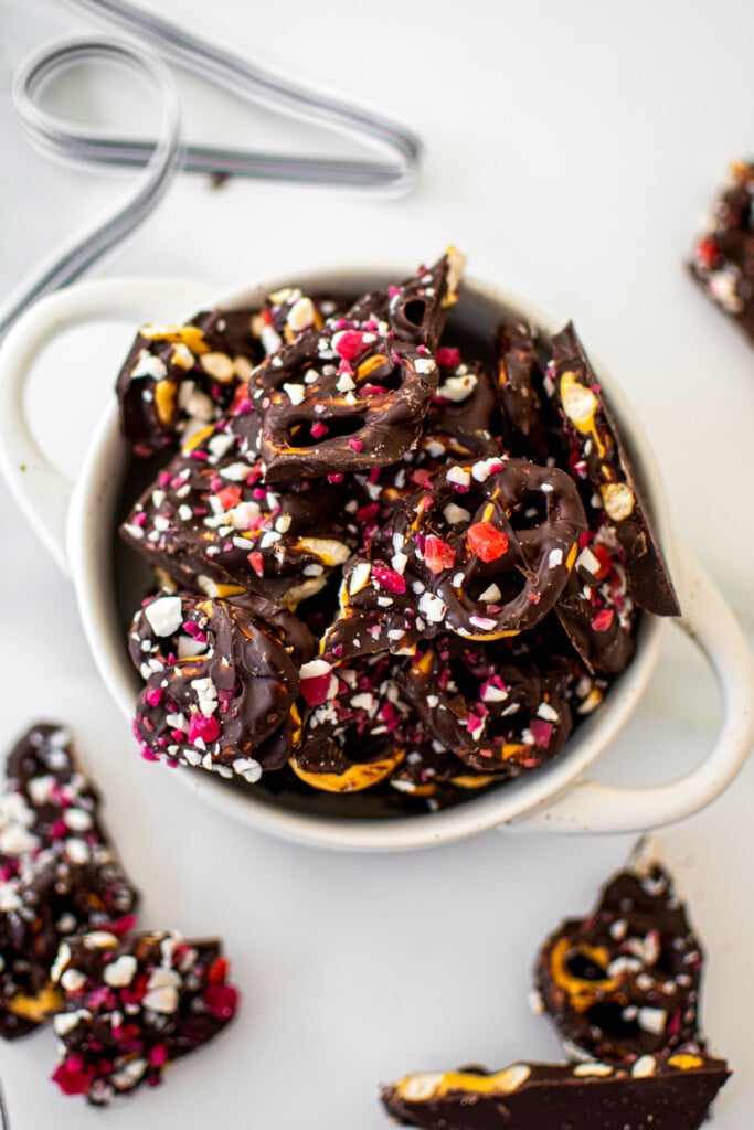 dark chocolate peppermint pretzel bark in a mini dutch oven on a white marble counter.