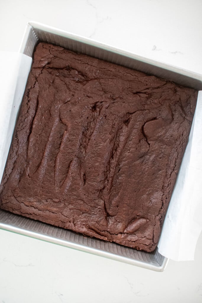 baked brownies in a baking pan on a marble counter.