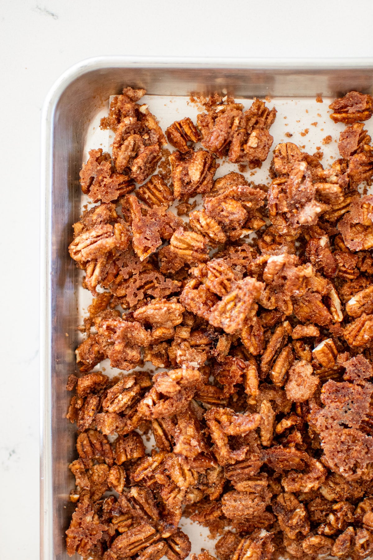 homemade candied pecans without eggs on a baking sheet.