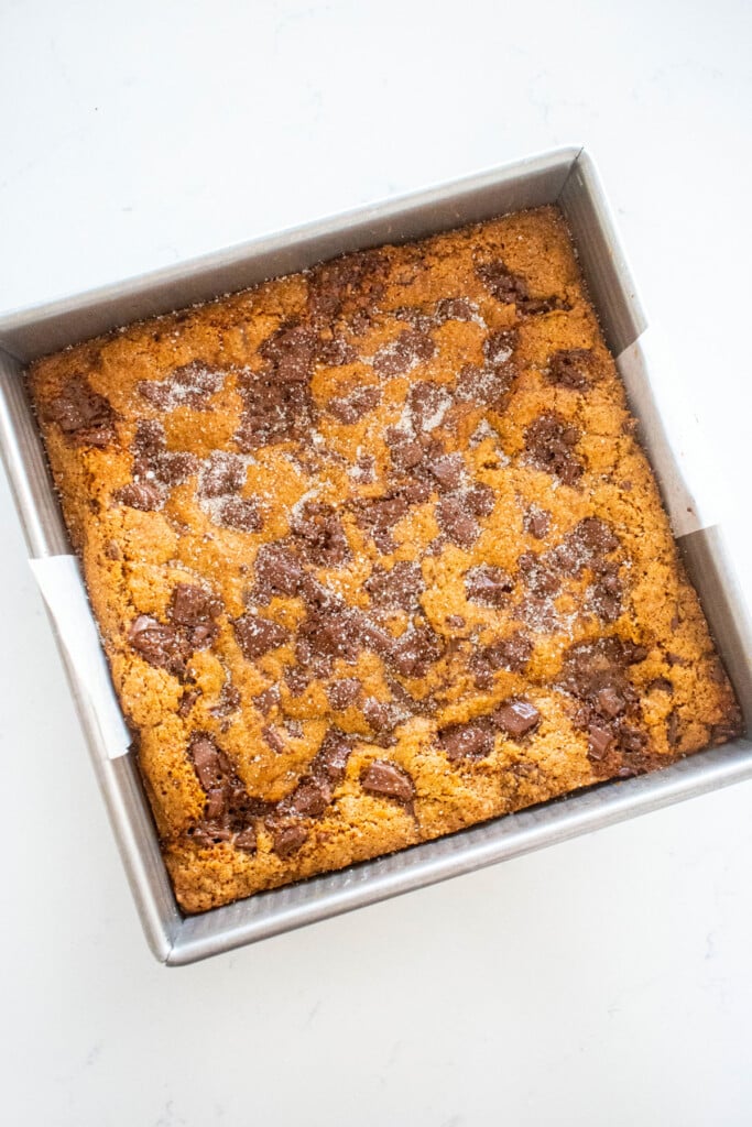 maple caramel dark chocolate gingerbread cookie bars in a baking pan on a marble counter.