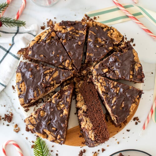 peppermint mocha coffee cake on a marble serving board cut into slices with candy canes all around it.