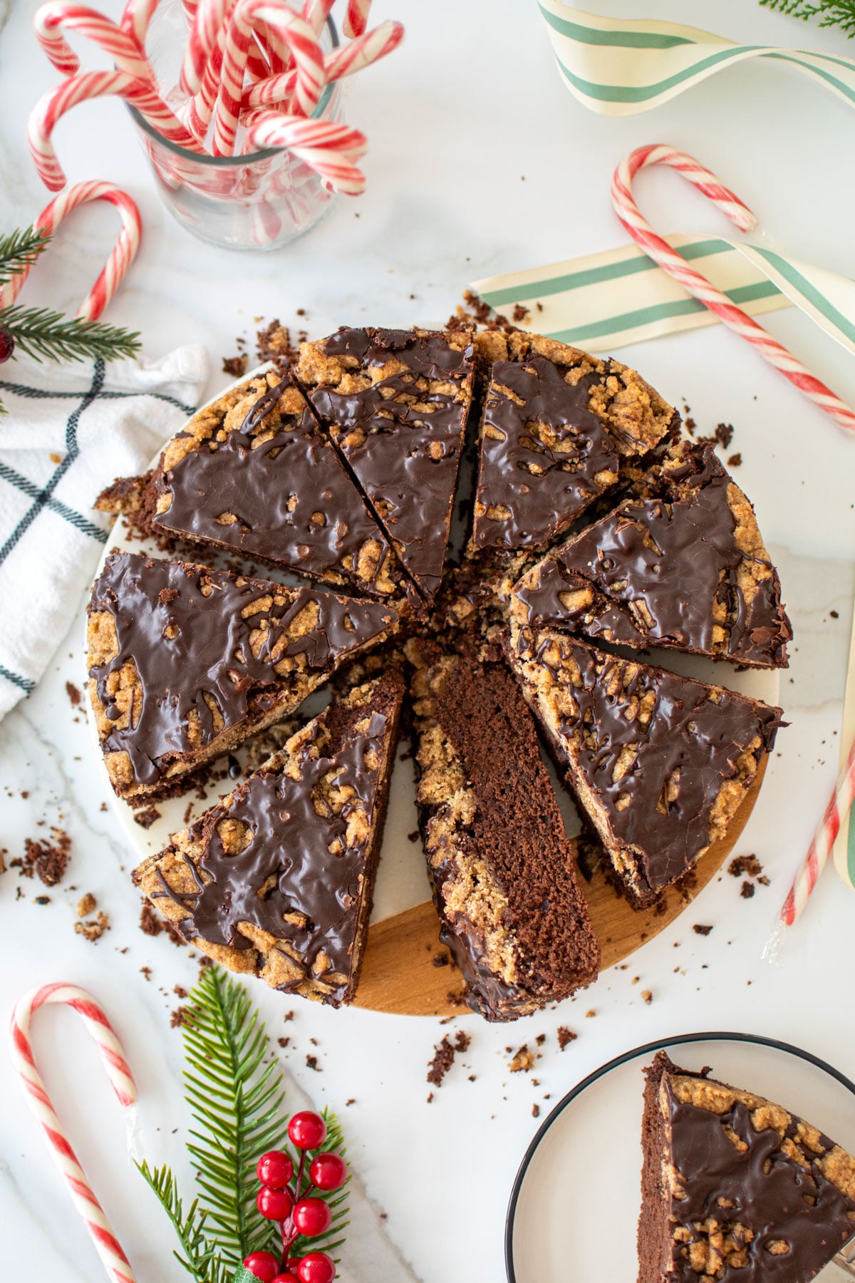 peppermint mocha coffee cake on a marble serving board cut into slices with candy canes all around it.
