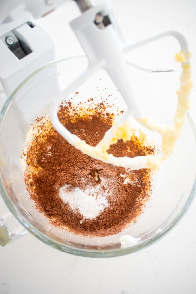 ingredients for peppermint mocha coffee cake in a glass mixing bowl on a white marble counter.