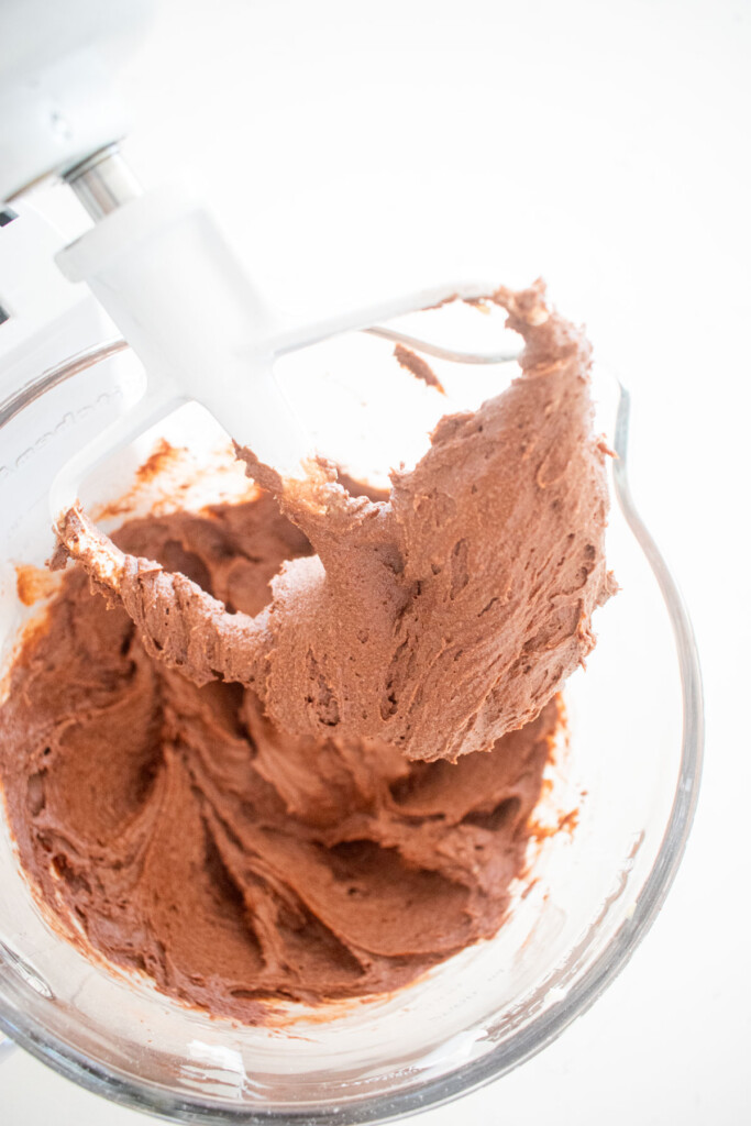 peppermint mocha coffee cake batter in a glass mixing bowl on a white marble counter.
