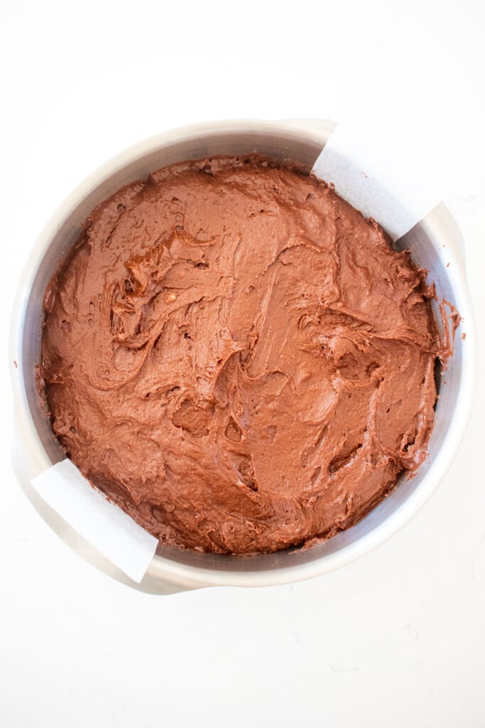 peppermint mocha coffee cake batter in a cake pan on a white marble counter.