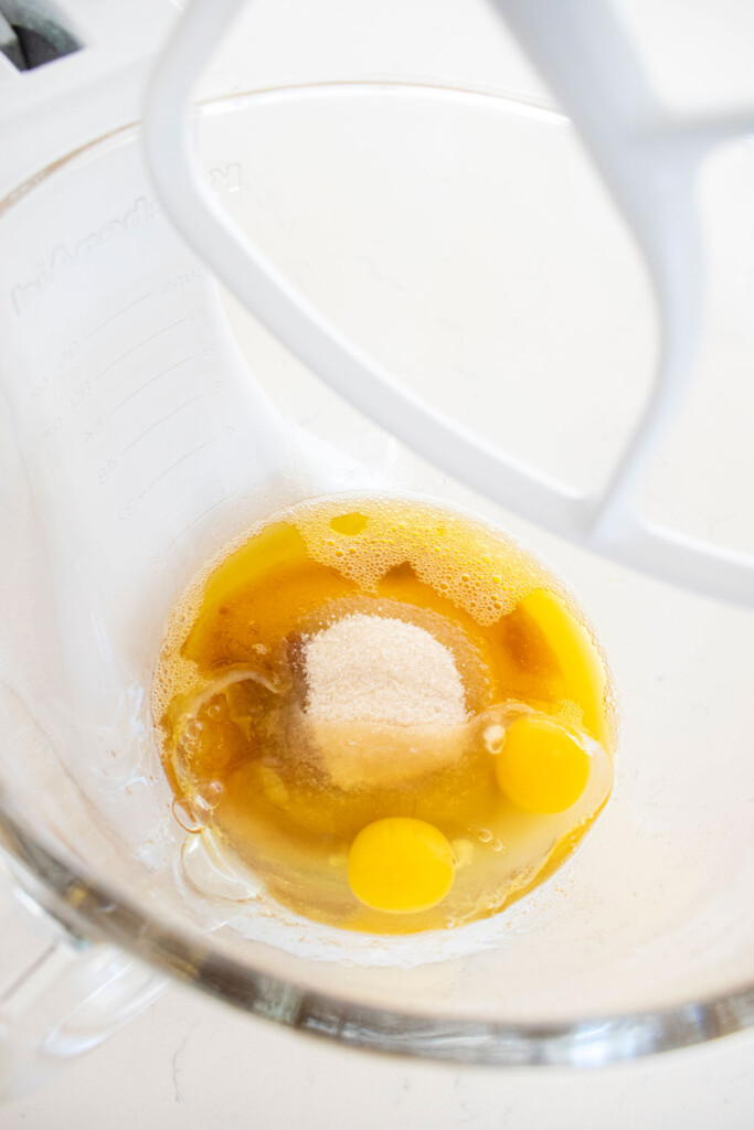 wet ingredients for brown butter caramel dark chocolate cookies in a glass mixing bowl on a marble counter.