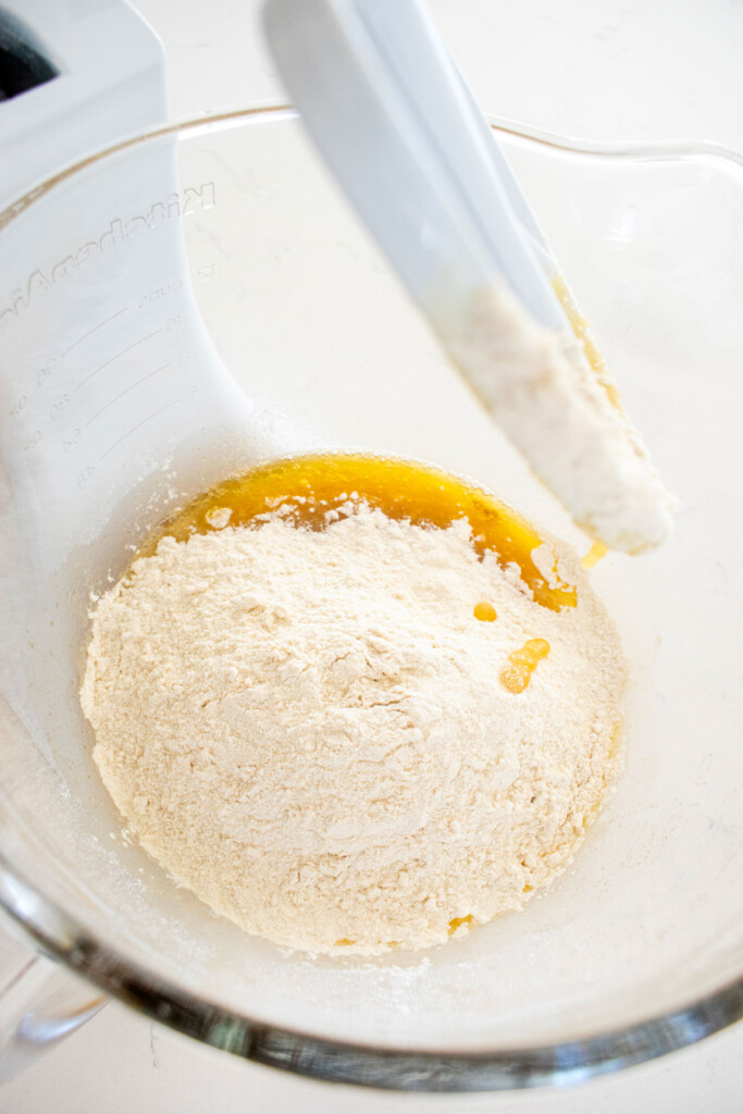 ingredients for brown butter caramel dark chocolate cookies in a glass mixing bowl on a marble counter.