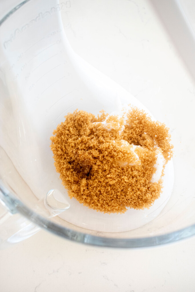 brown sugar and coconut oil in a glass mixing bowl on a marble counter.