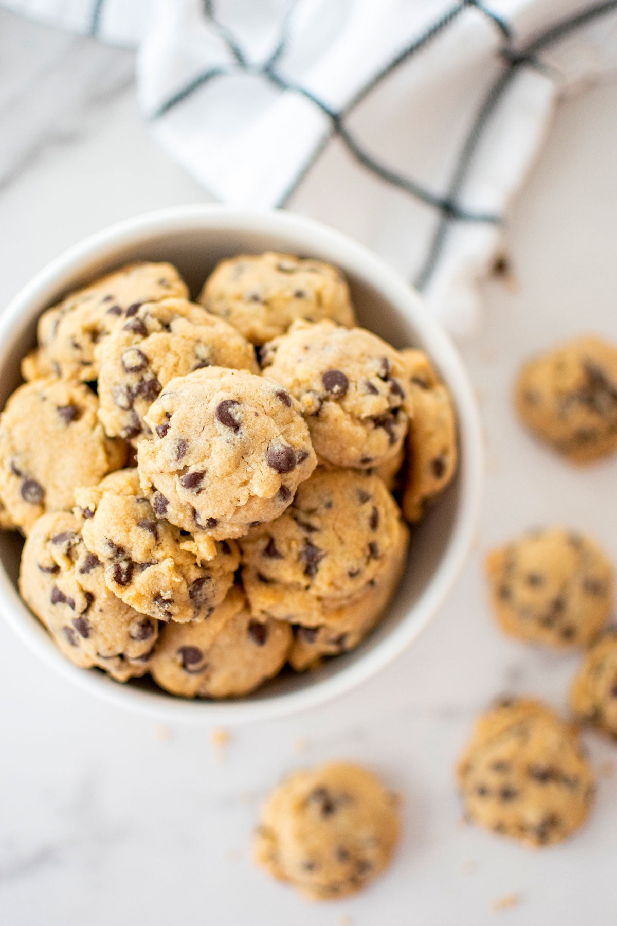 bowl of brown sugar chocolate chip mini cookies on a marble counter.
