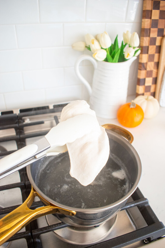 boiled chicken in a small pot on the stovetop.