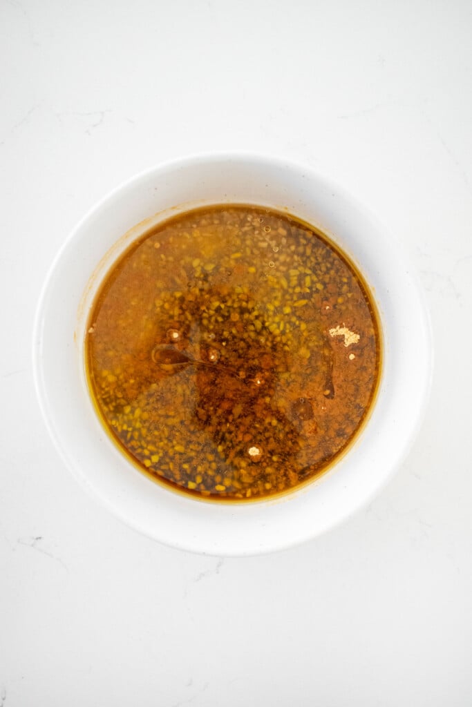 honey garlic marinade in a bowl on a white marble counter.