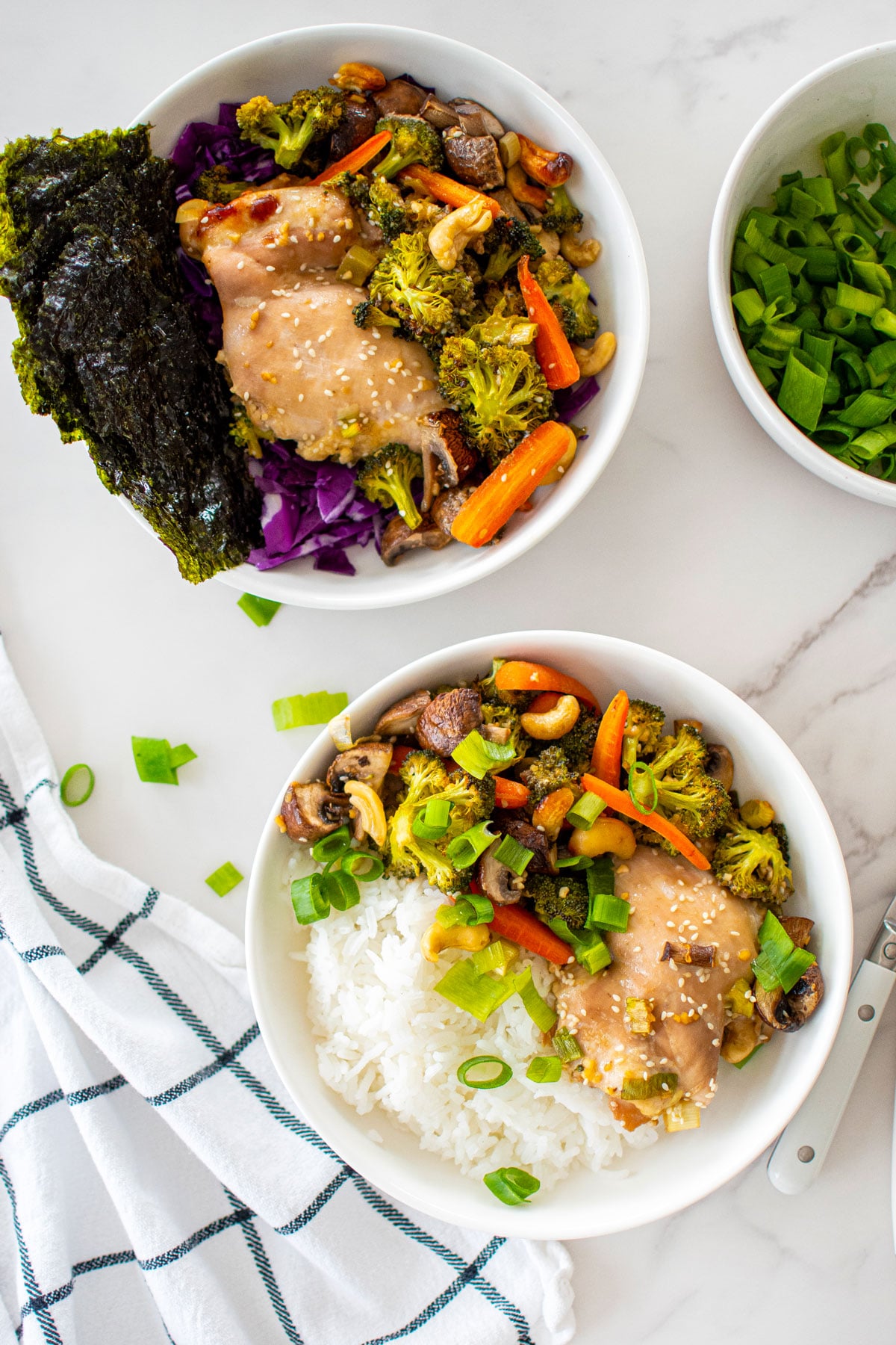 honey garlic chicken sheet pan dinner in a bowls on a white marble counter.