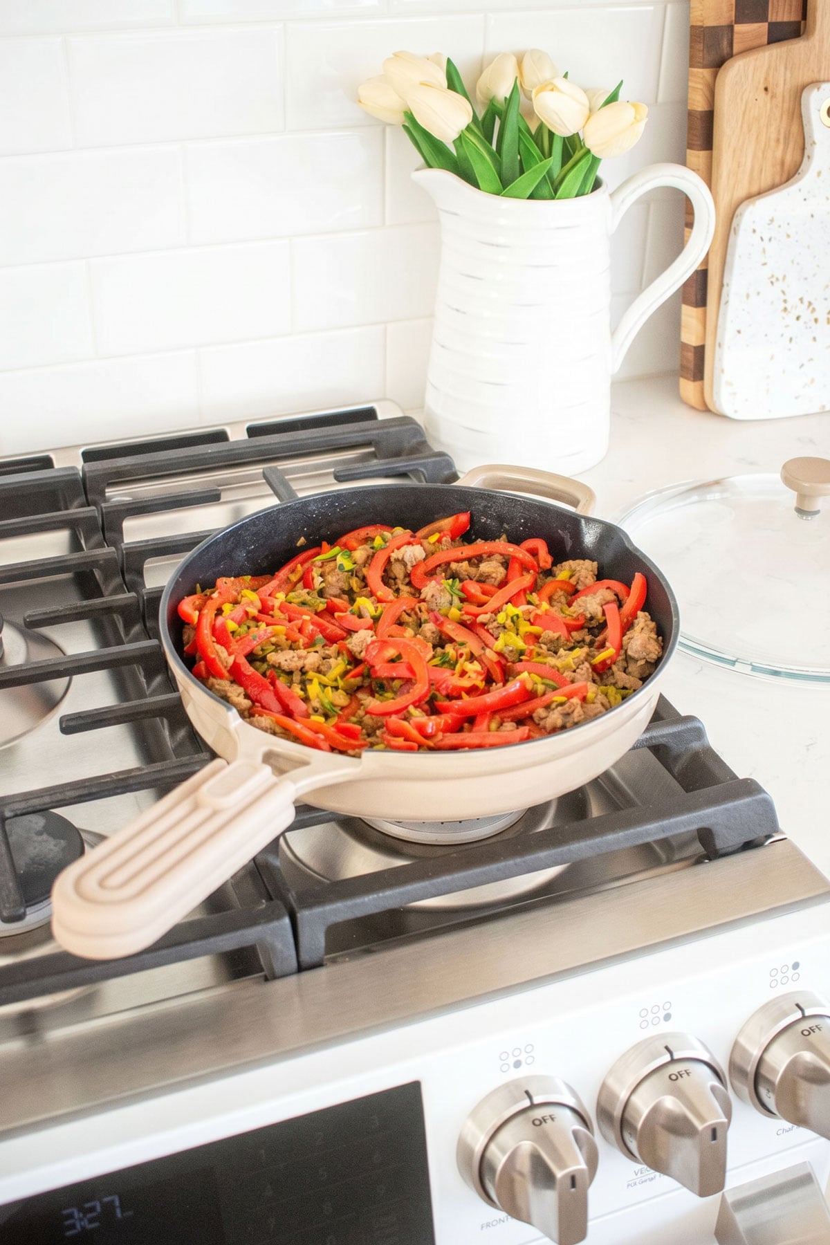 our place always cast iron pan with red pepper zucchini turkey dish on the stovetop.