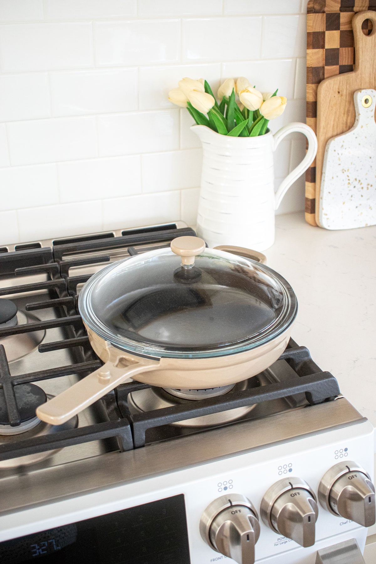 tan our place cast iron skillet with a glass lid on the stovetop.