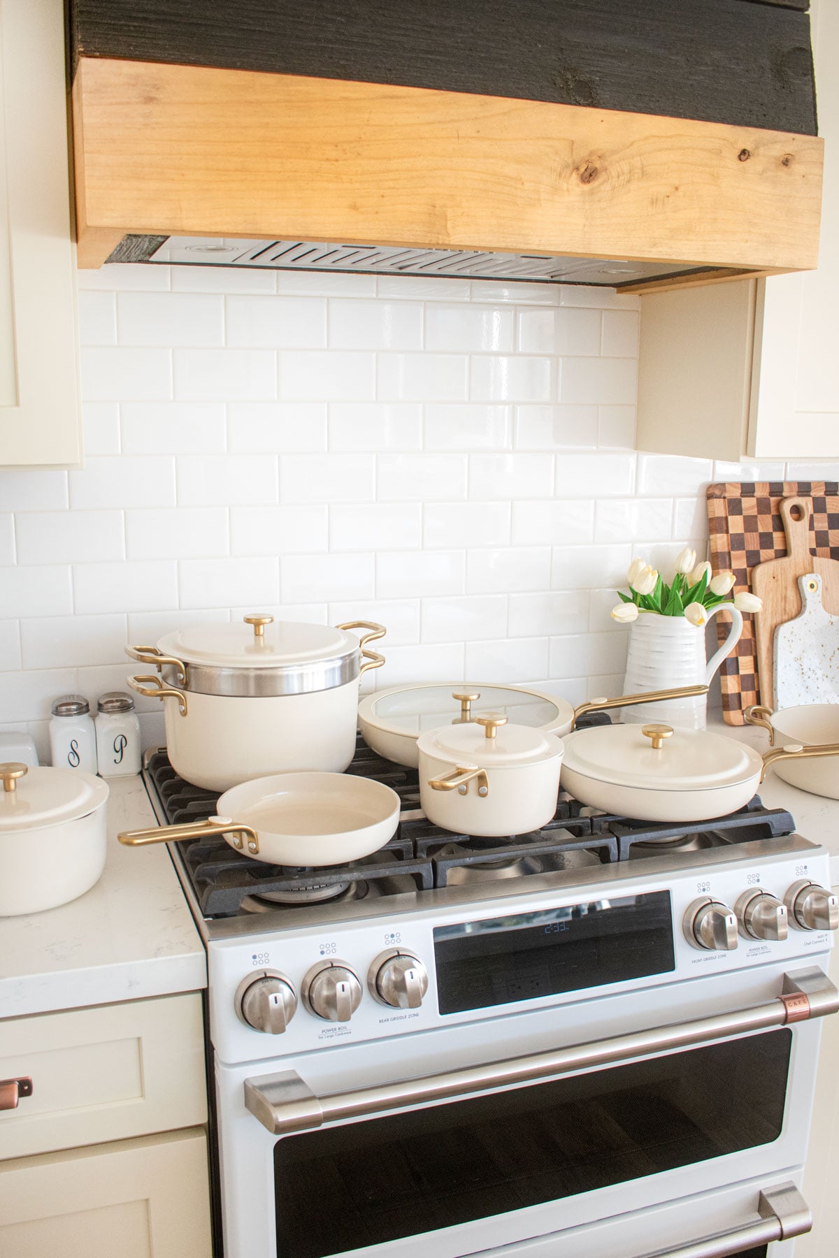 our place essentials complete cookware set in cream on a stovetop.