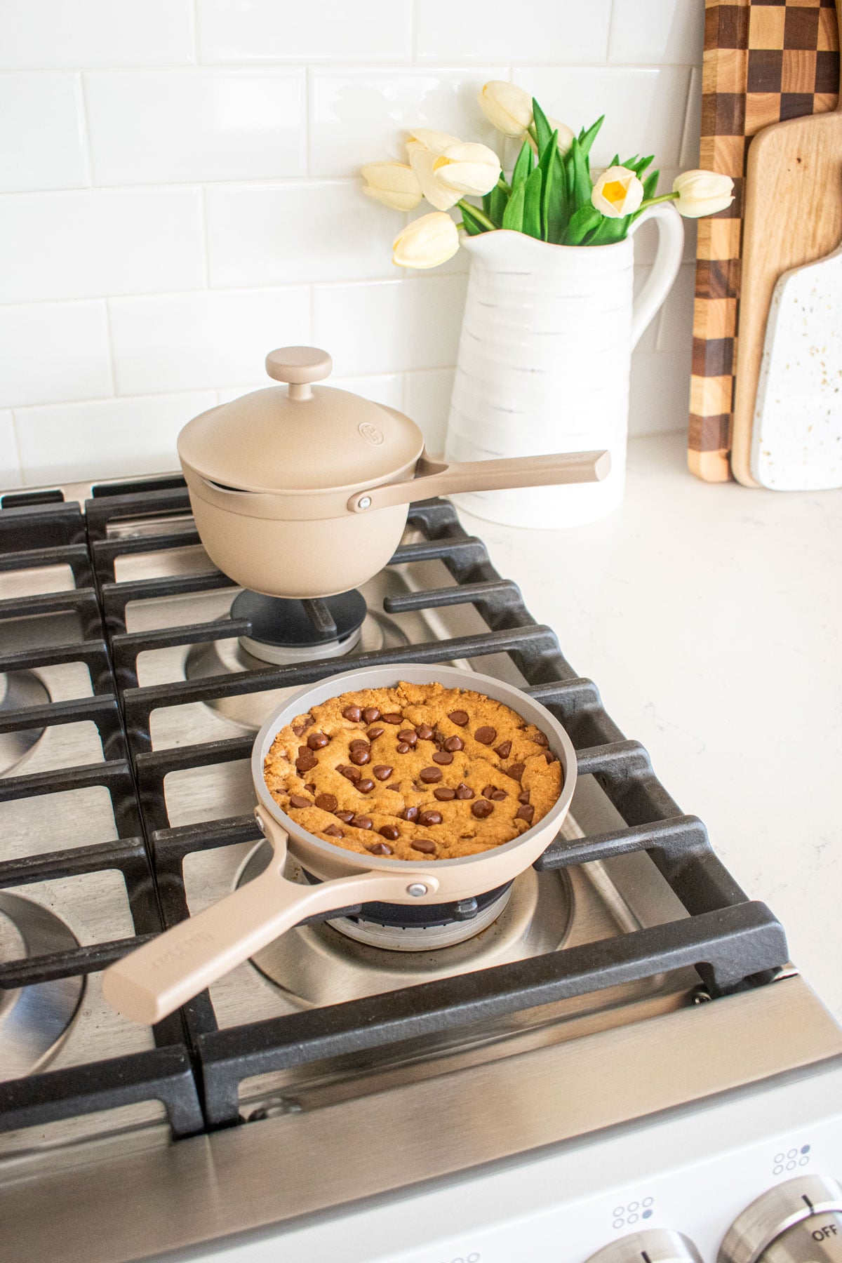cookie skillet in a tiny skillet on top of a stovetop and a tiny pot on the stovetop too.