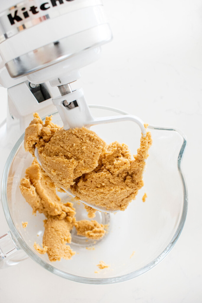 valanetines day smore bars cookie dough in a glass stand mixing bowl on a white marble counter.