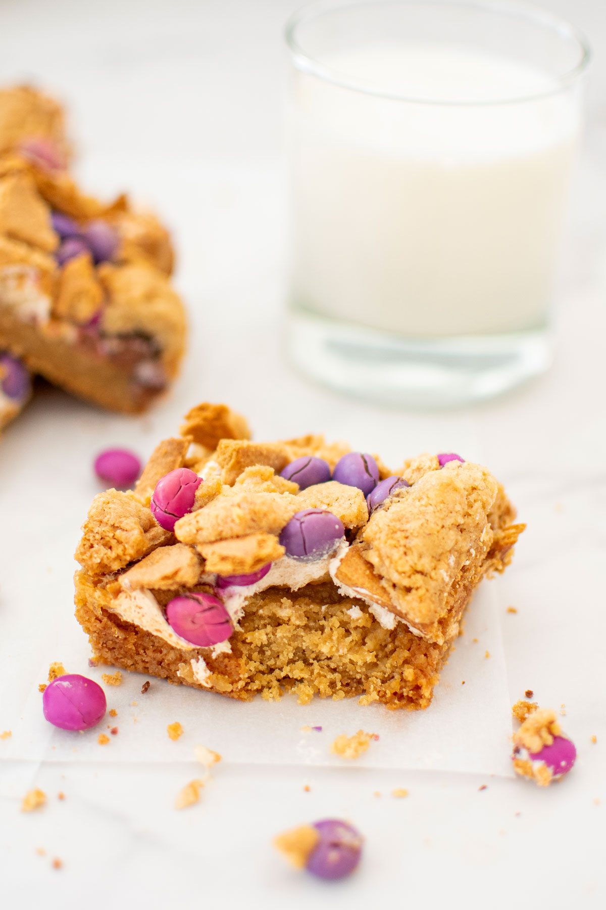 valentine's day smore bar with a bite taken out on a marble counter with a glass of milk.