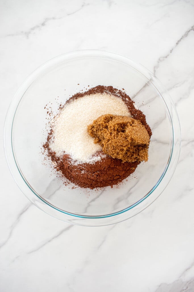 dry ingredients for chocolate strawberry crumb bars in a glass mixing bowl on a white marble counter.