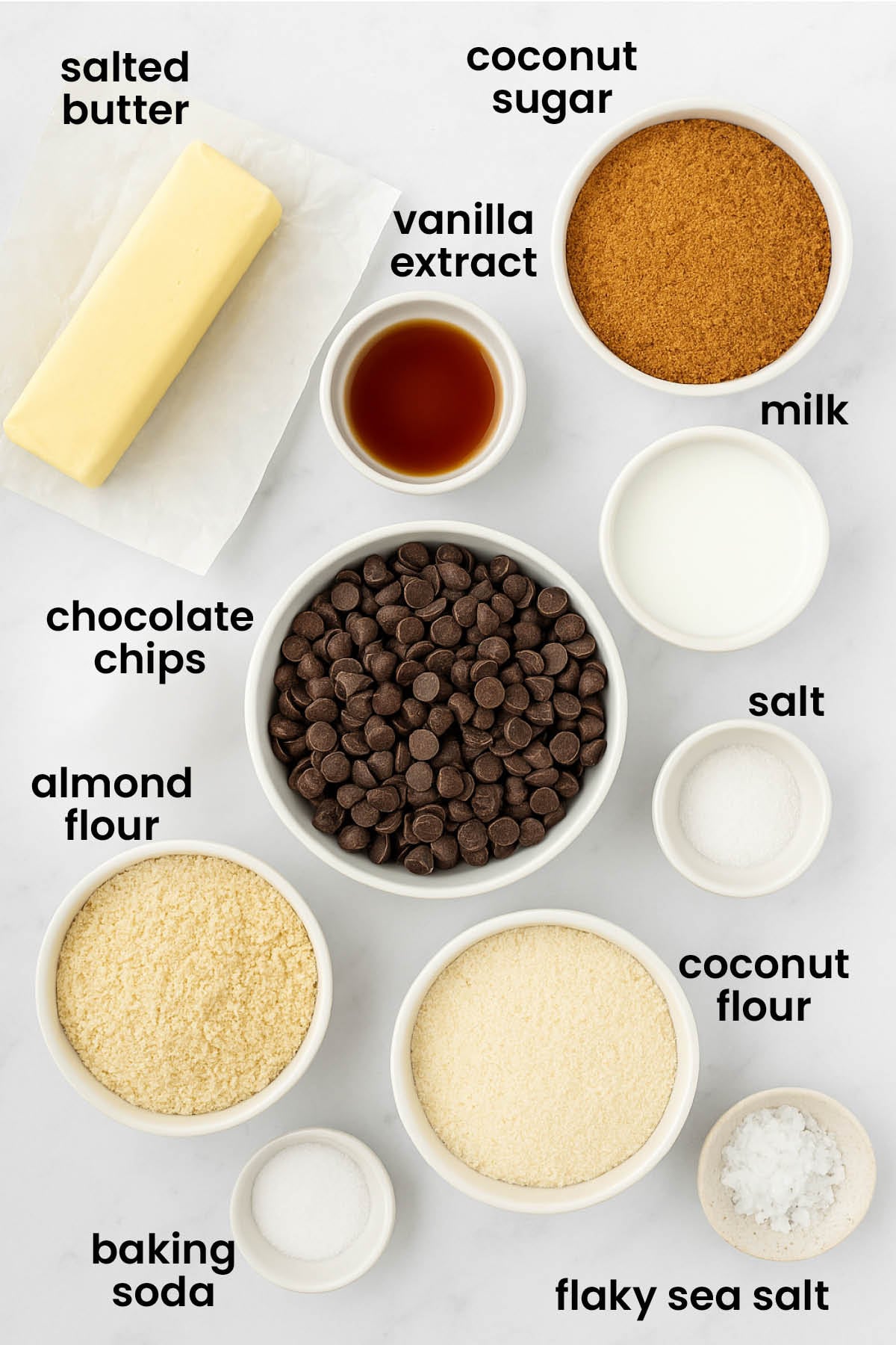 individual ingredients for the healthy chocolate chip cookies with coconut sugar laid out against a white background.