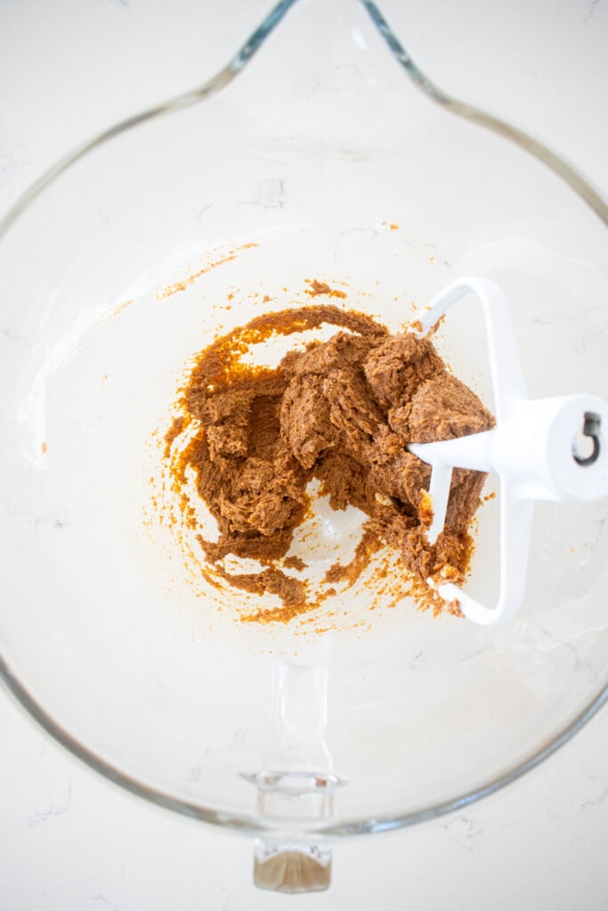 creamed butter and coconut sugar in a glass mixing bowl on a marble counter.