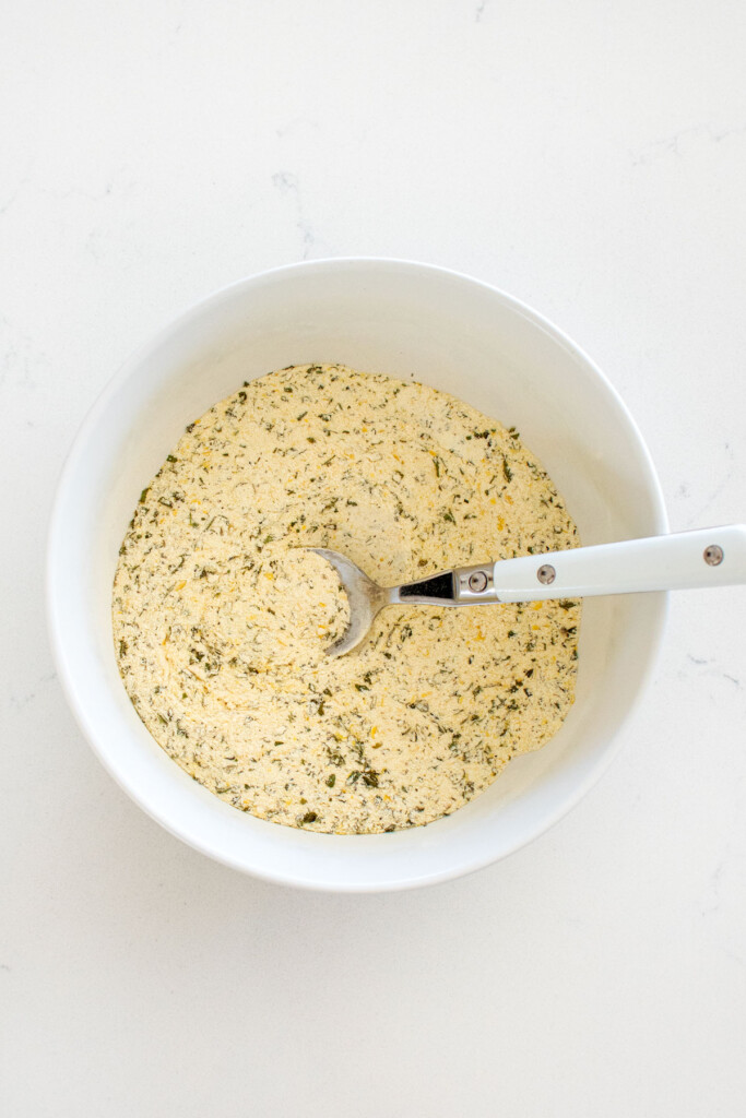 homemade ranch seasoning mixed together in a bowl on a white marble countertop,