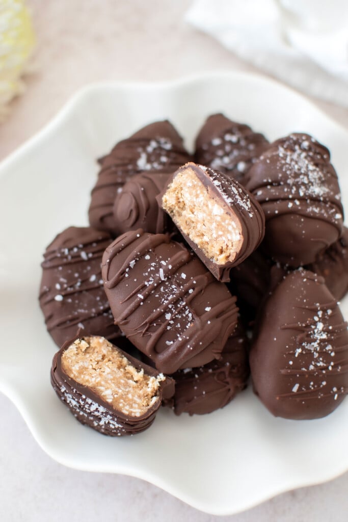 dark chocolate coconut almond butter eggs on a plate, one cut in half to reveal the center.
