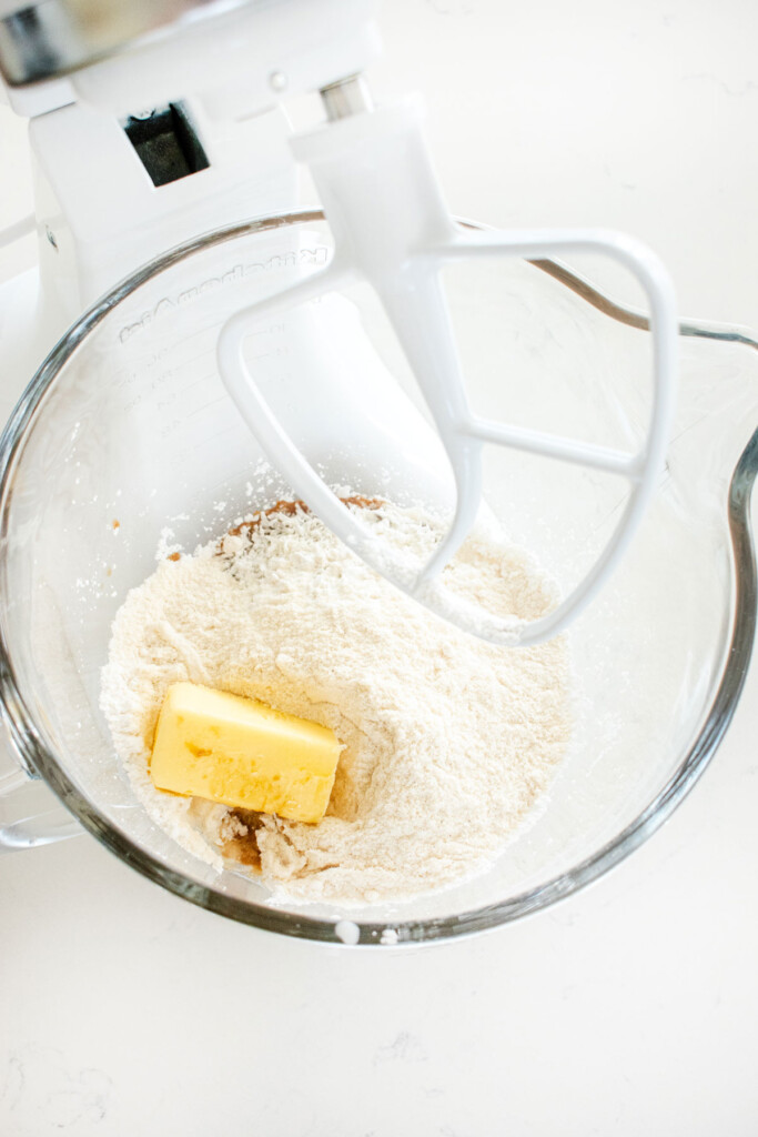ingredients for dark chocolate coconut almond butter eggs in a glass stand mixing bowl on a marble counter.