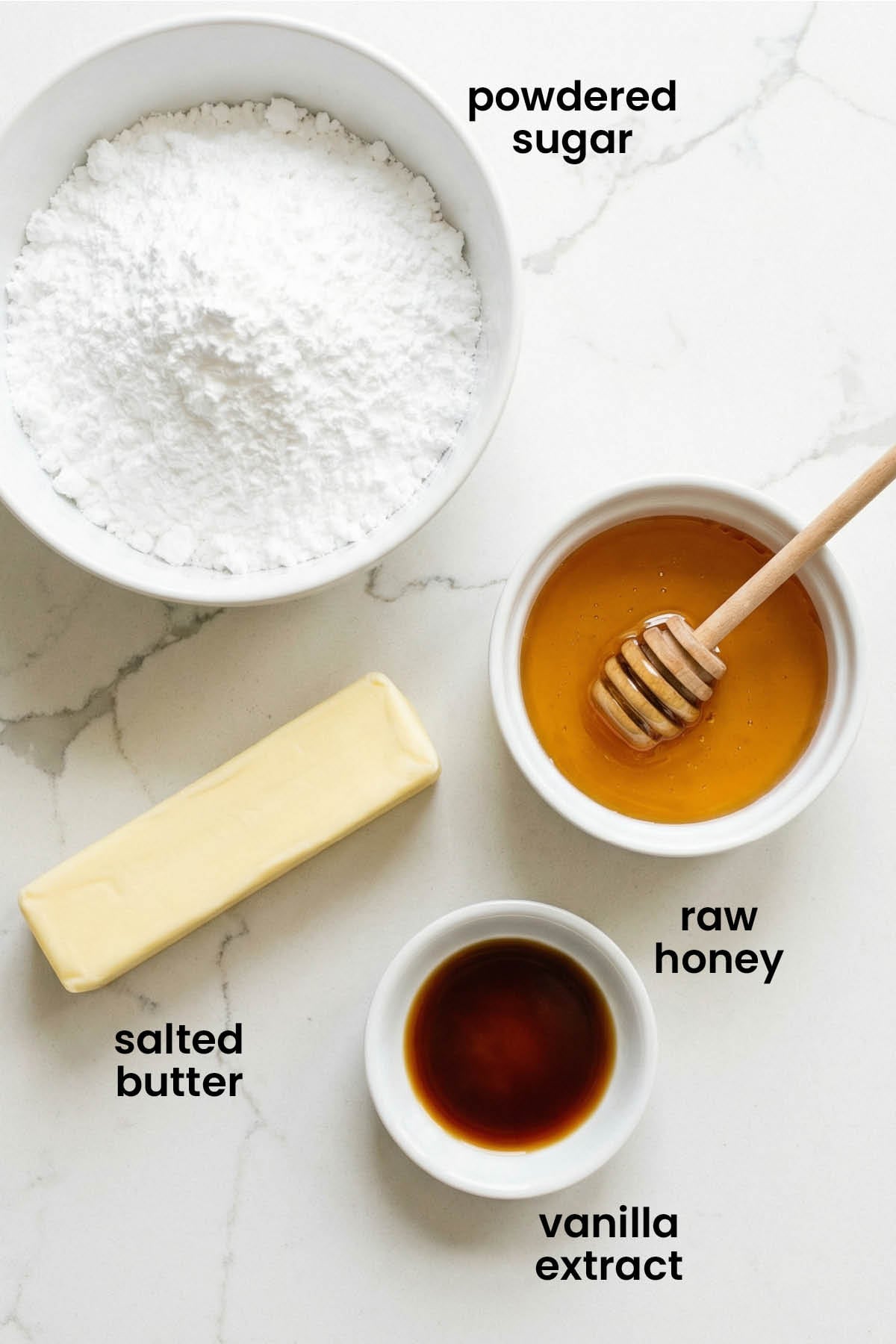 individual ingredients for honey buttercream frosting laid out against a white background.