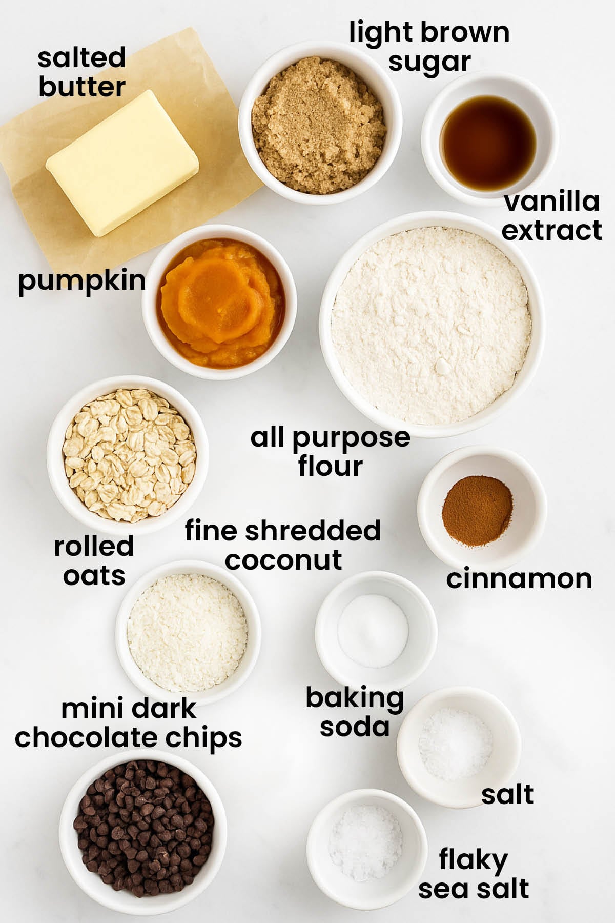 individual ingredients for pumpkin oatmeal chocolate chip cookies laid out against a white background.
