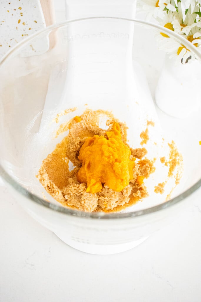 creamed butter and light brown sugar in a glass mixing bowl with pumpkin puree.