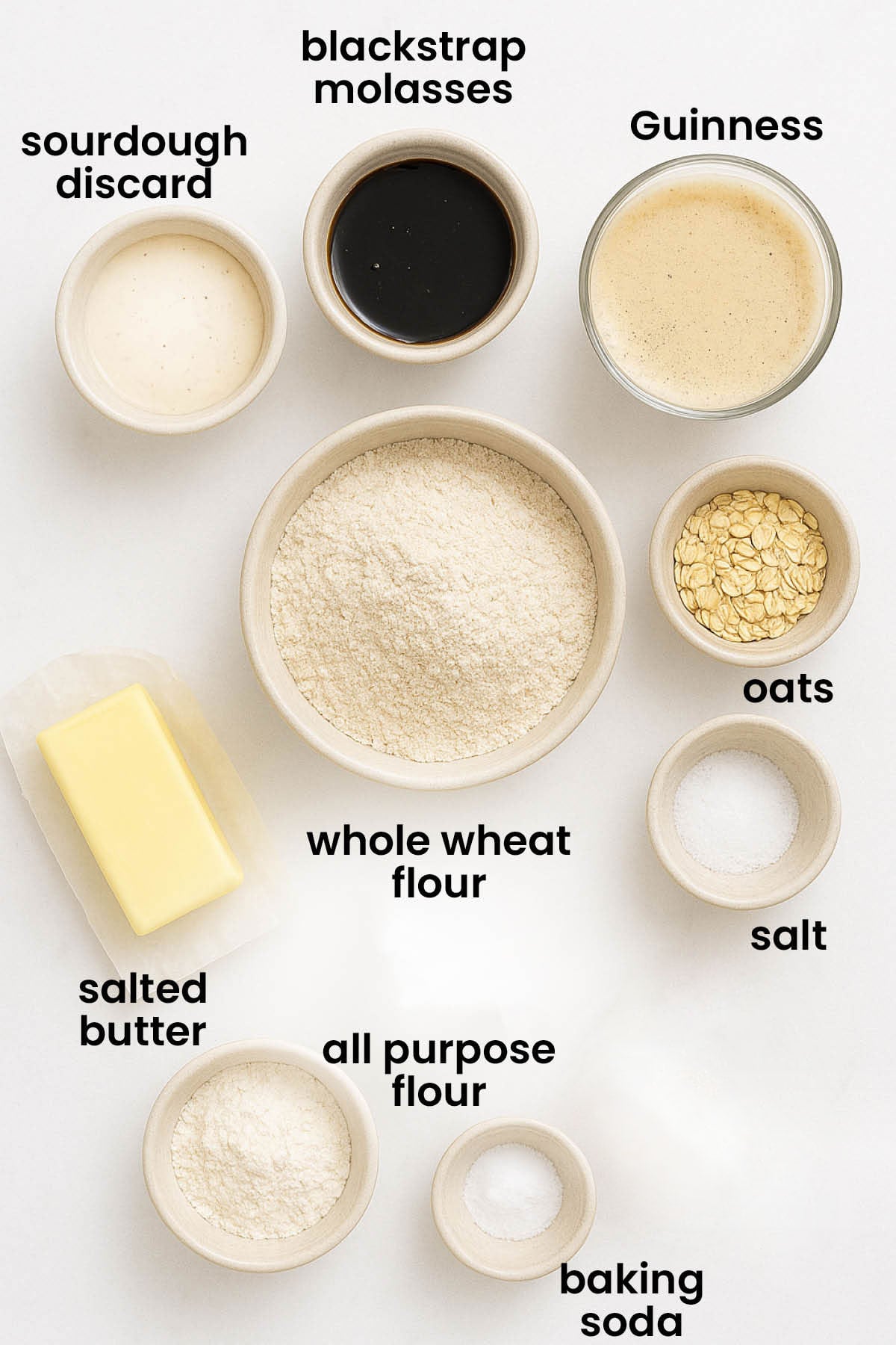 individual ingredients for sourdough irish brown bread with guinness laid out against a white background.