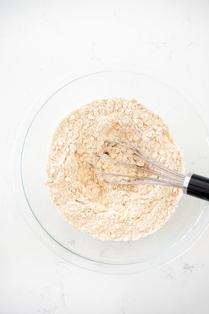 dry ingredients for sourdough irish brown bread in a glass mixing bowl on a white marble counter.