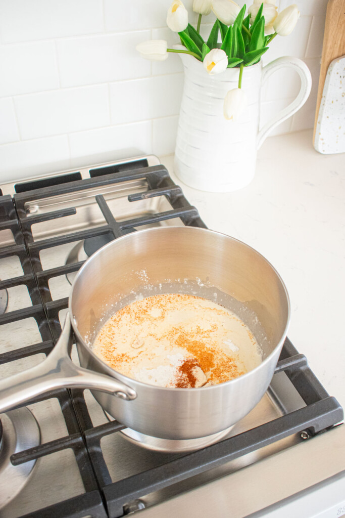 bone broth, buttermilk and spices in a pot over the stovetop.