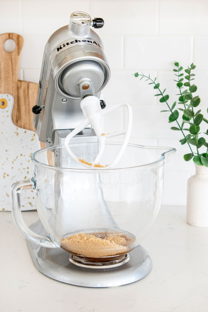 ingredients for vegan blueberry bars in the bowl of a stand mixer on a white marble counter.