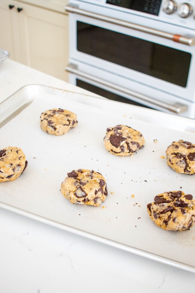 vegan oreo chocolate chip cookie dough balls on a baking sheet on the counter.