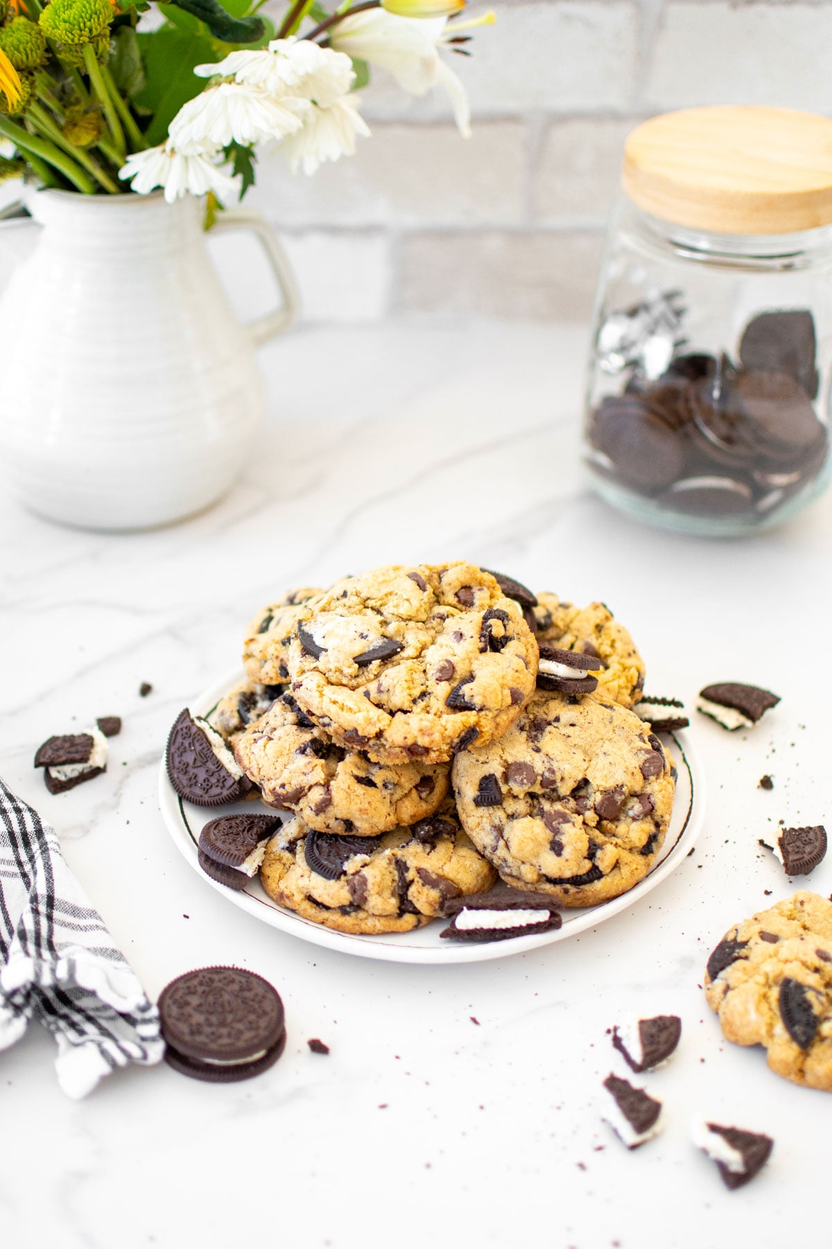 vegan oreo chocolate chip cookies on a plate on a white marble counter.