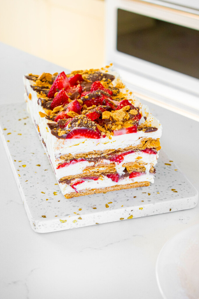 neapolitan icebox cake on a white marble serving board on the kitchen counter.