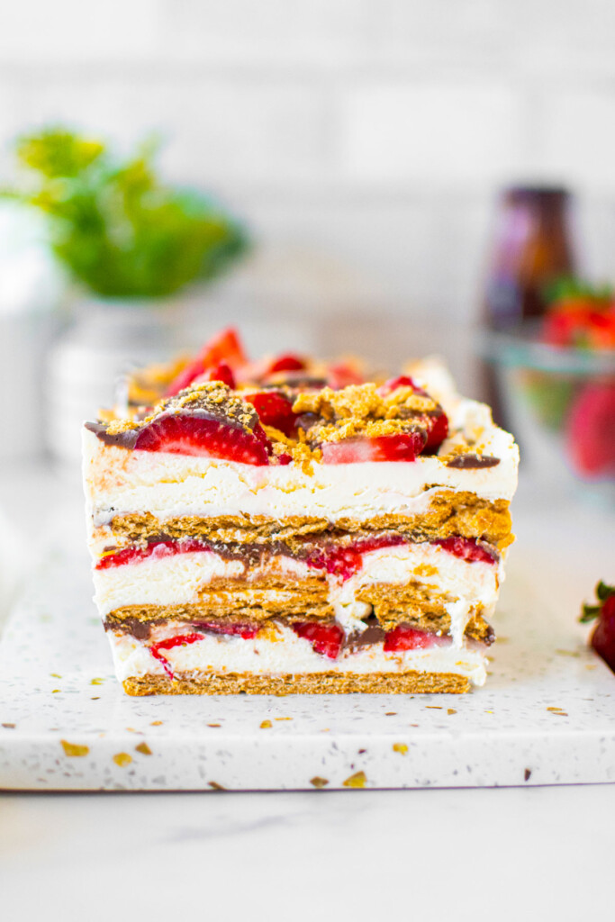 neapolitan icebox cake on a white marble serving board on a white marble table.