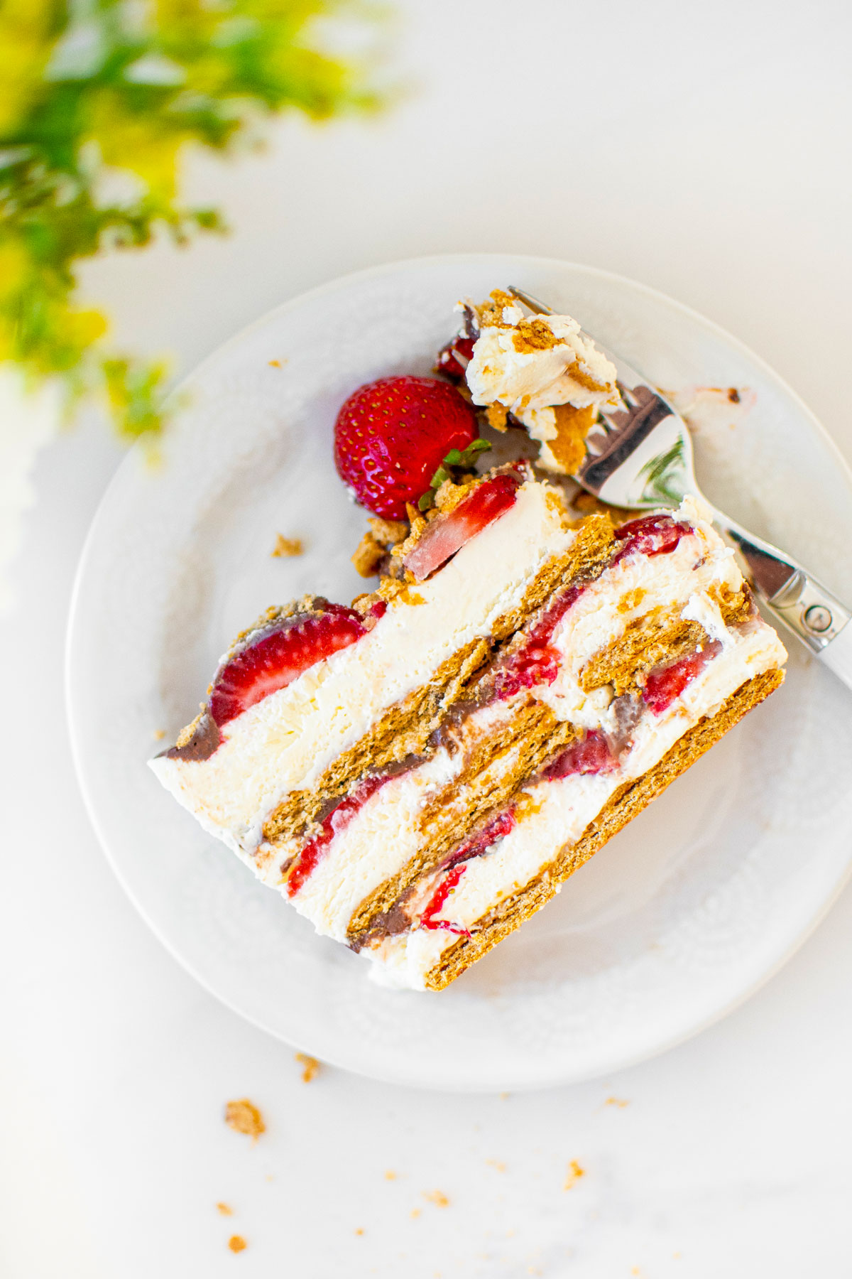 slice of neapolitan icebox cake on a white plate on a marble counter.