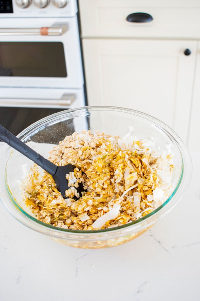 pumpkin granola for dogs being mixed together in a mixing bowl.