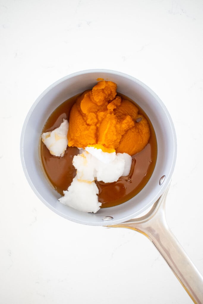 pumpkin, honey, and coconut oil in a small pot on the counter.