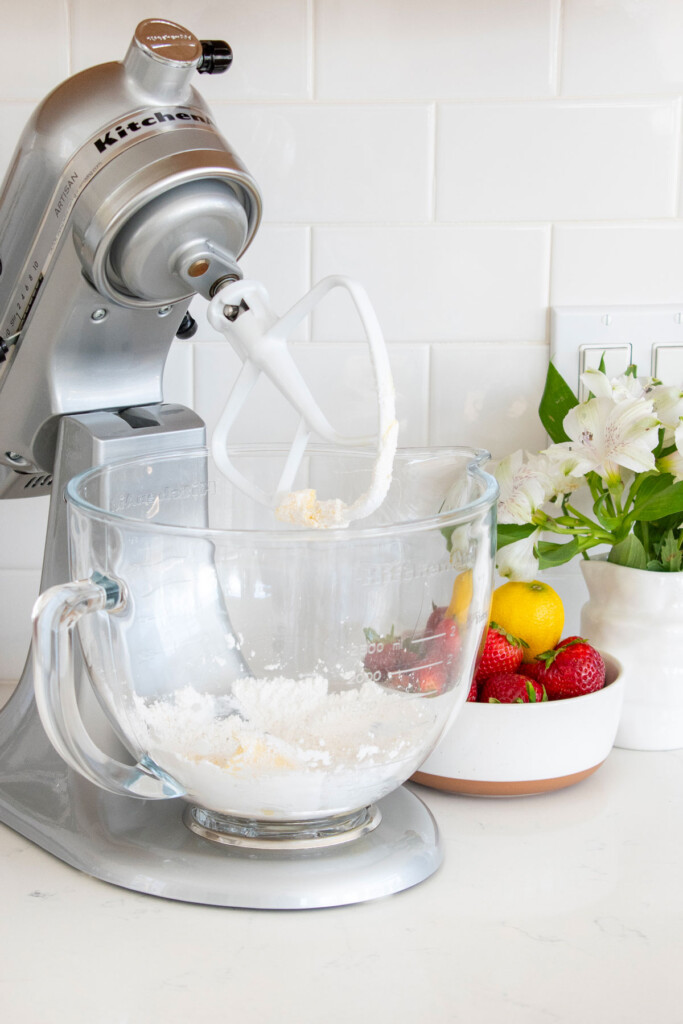 sourdough strawberry pop tart dough being mixed in a mixer on a white marble countertop.