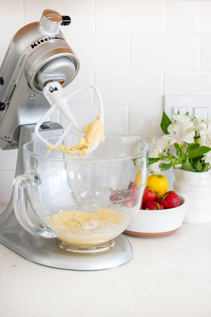 sourdough strawberry pop tart dough being mixed in a mixer on a white marble countertop.