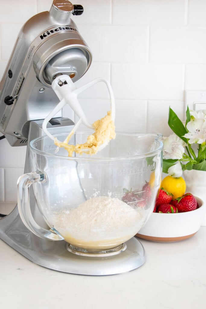 sourdough strawberry pop tart dough being mixed in a mixer on a white marble countertop.