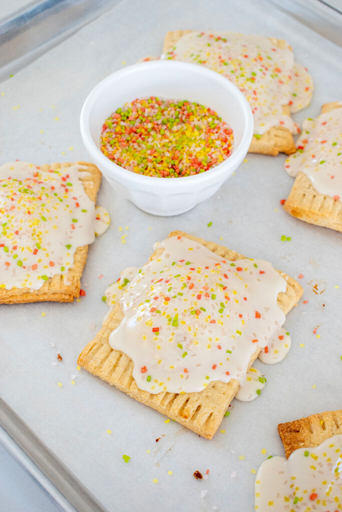 sourdough strawberry pop tarts on a baking sheet with natural decorating sugars.