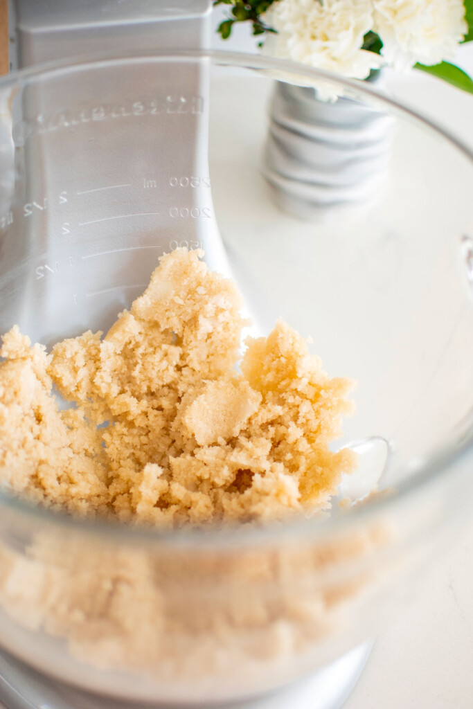 vegan lemon chamomile tea cake batter being made in a glass stand mixing bowl.