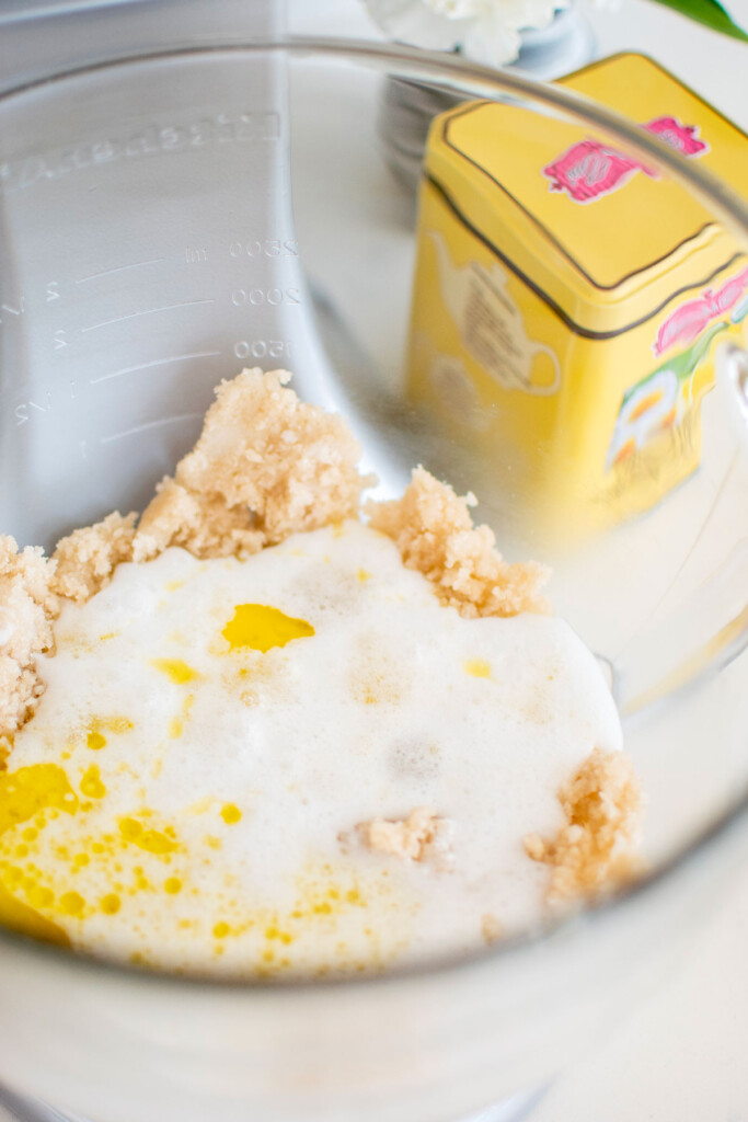 ingredients for vegan lemon chamomile tea cake in a glass mixing bowl on a white marble counter.