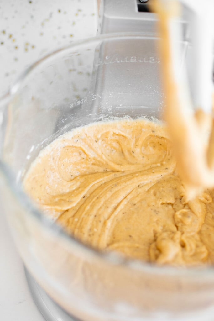 vegan lemon chamomile tea cake batter in a stand mixing bowl on a white marble counter.