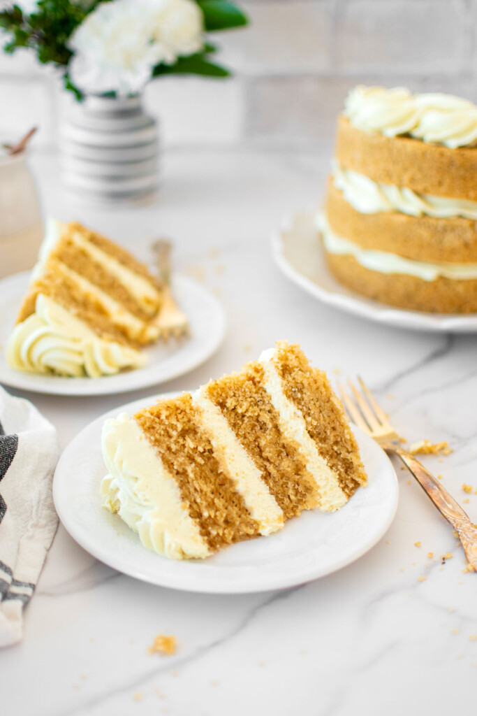 vegan lemon chamomile tea cake slices on cake plates on a marble counter.